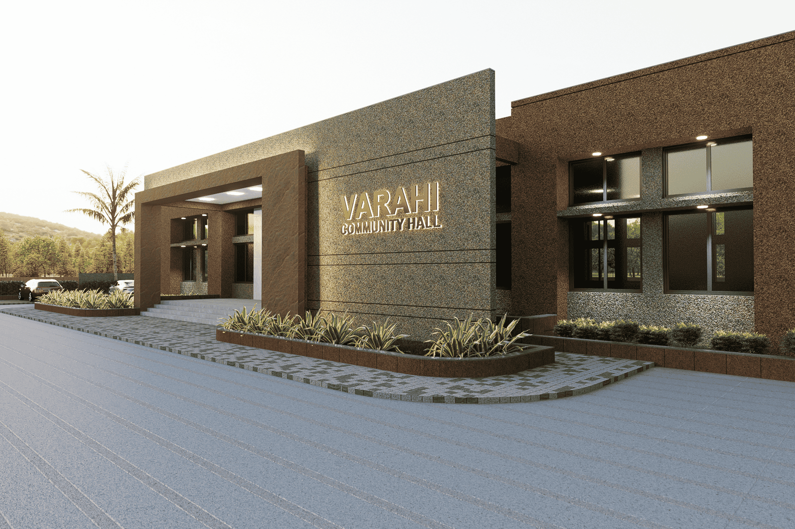 - Exterior view of Varahi Community Hall showcasing a welcoming entrance canopy, local decorative motifs, and landscaped forecourt - Interior shot of the main hall with a flexible open layout, movable seating stacks, and stage area ready for events - Festive gathering inside the hall with residents seated around long tables, colorful decorations, and natural light filtering through clerestory windows - Close-up of ornamental wall patterns and exposed wooden beams that reflect Varahi’s cultural craftsmanship - Night-time façade illuminated by warm uplights, highlighting the building’s form and its integration with surrounding greenery