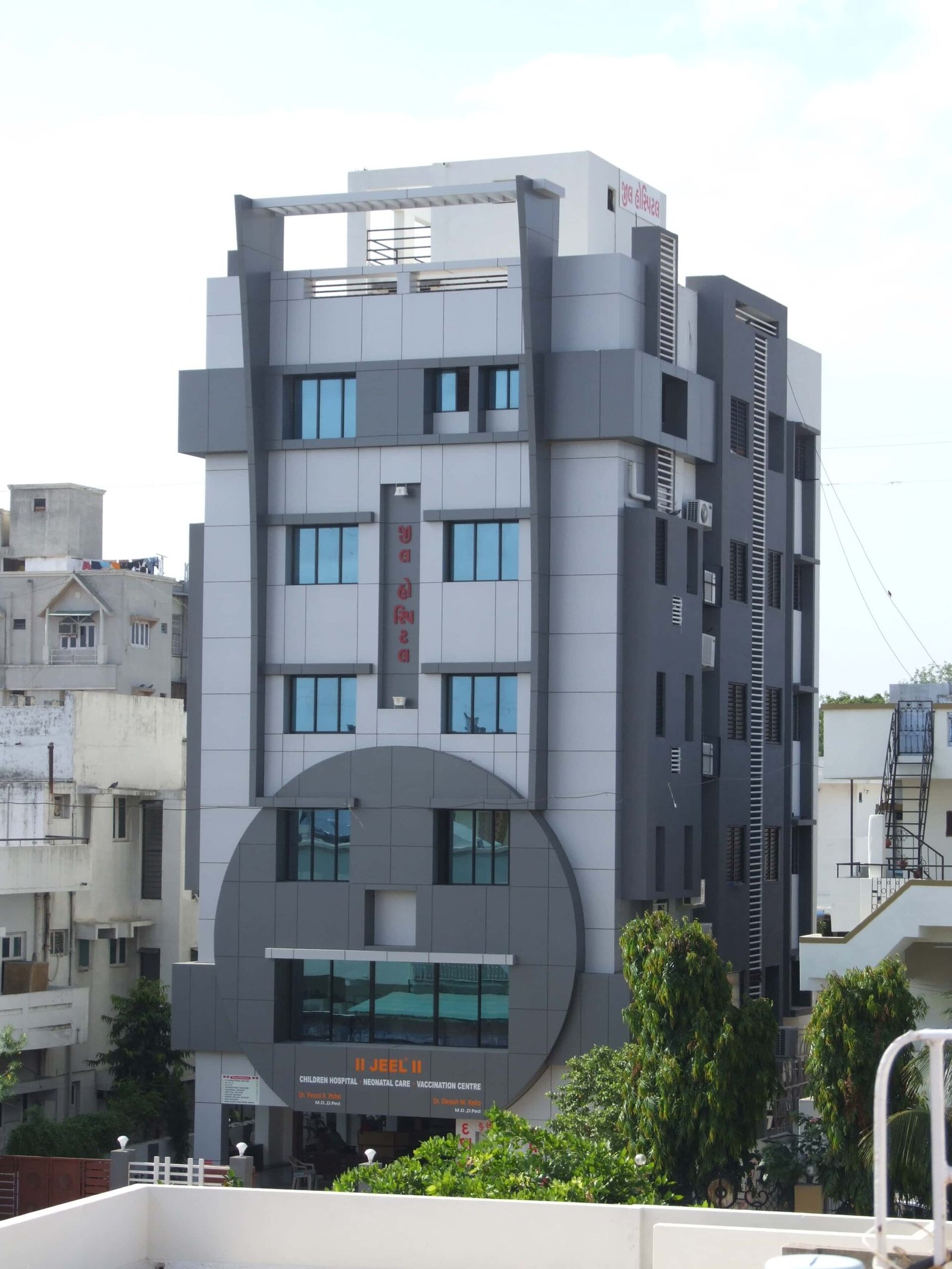 - Front elevation of Jeel Children Hospital in Ahmedabad showing a colourful, child-friendly façade with playful architectural motifs - Interior view of a pediatric ward at Jeel Children Hospital with vibrant wall art, kid-sized furniture, and natural daylight - Interactive play area in the hospital’s family lounge featuring whimsical sculptures, seating nooks, and soft flooring - State-of-the-art operating theatre at Jeel Children Hospital with advanced medical equipment and efficient room layout - Quiet family support room at Jeel Children Hospital with cosy seating, warm lighting, and privacy partitions