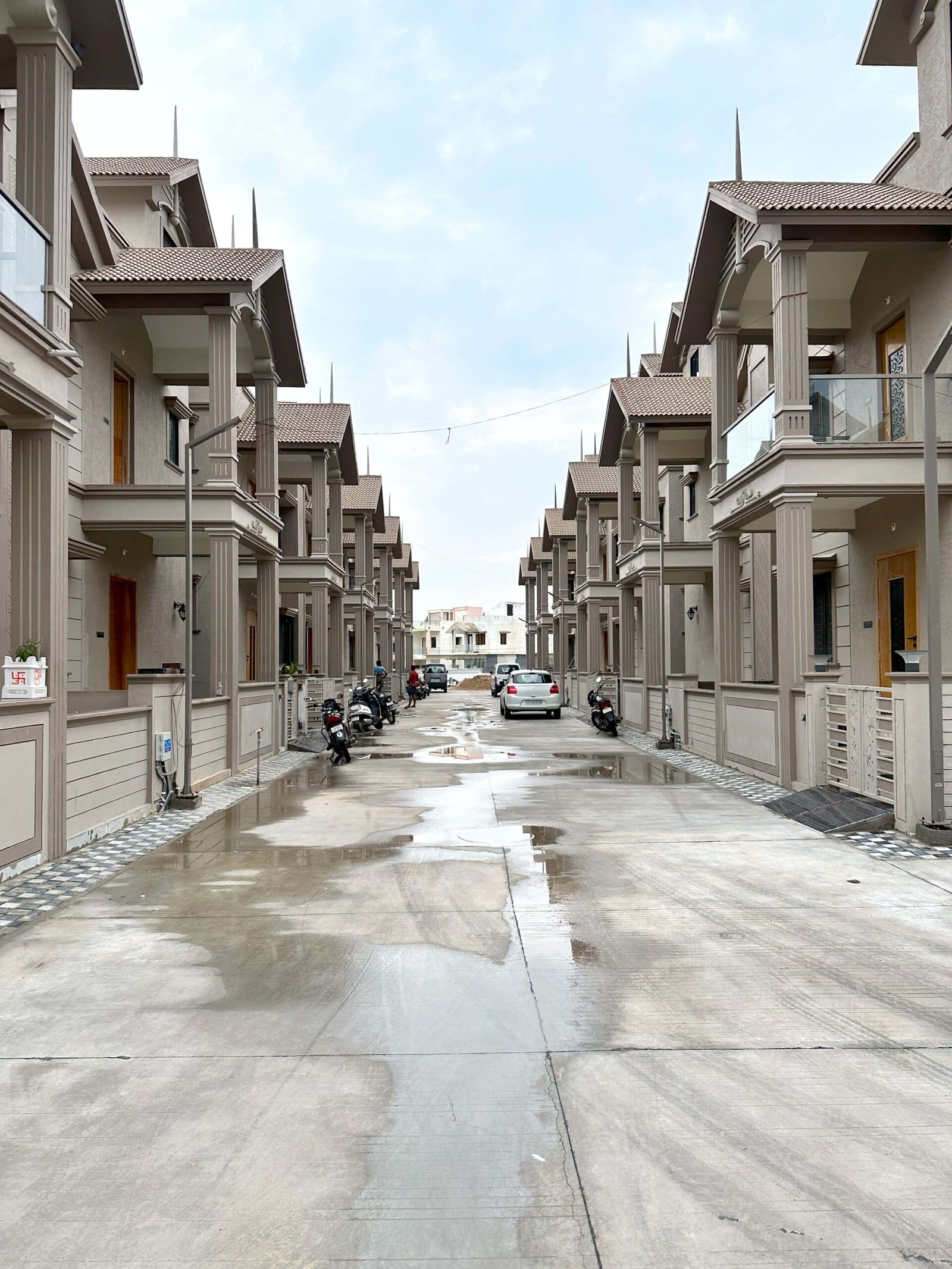 - Kalp Heritage – Colonial Style 3 BHK Bungalows in Mehsana - Kalp Heritage by Shree Hari Buildcon Mehsana Residential Project - Traditional Indian Bungalows with Landscape Design Kalp Heritage - 3 BHK Heritage Bungalows in Mehsana Kalp Groups - Kalp Heritage – Colonial Style Bungalows in Mehsana - 3 BHK Residential Scheme by Shree Hari Buildcon - Kalp Heritage – Traditional Architecture Meets Modern Living - Kalp Heritage entrance with Doric column and colonial façade - Gabled roof bungalow design in Mehsana’s Kalp Heritage - Landscaped open spaces in Kalp Heritage residential scheme - Symmetrical windows and neutral tones in Kalp Heritage bungalows - Community-friendly layout with green areas at Kalp Heritage