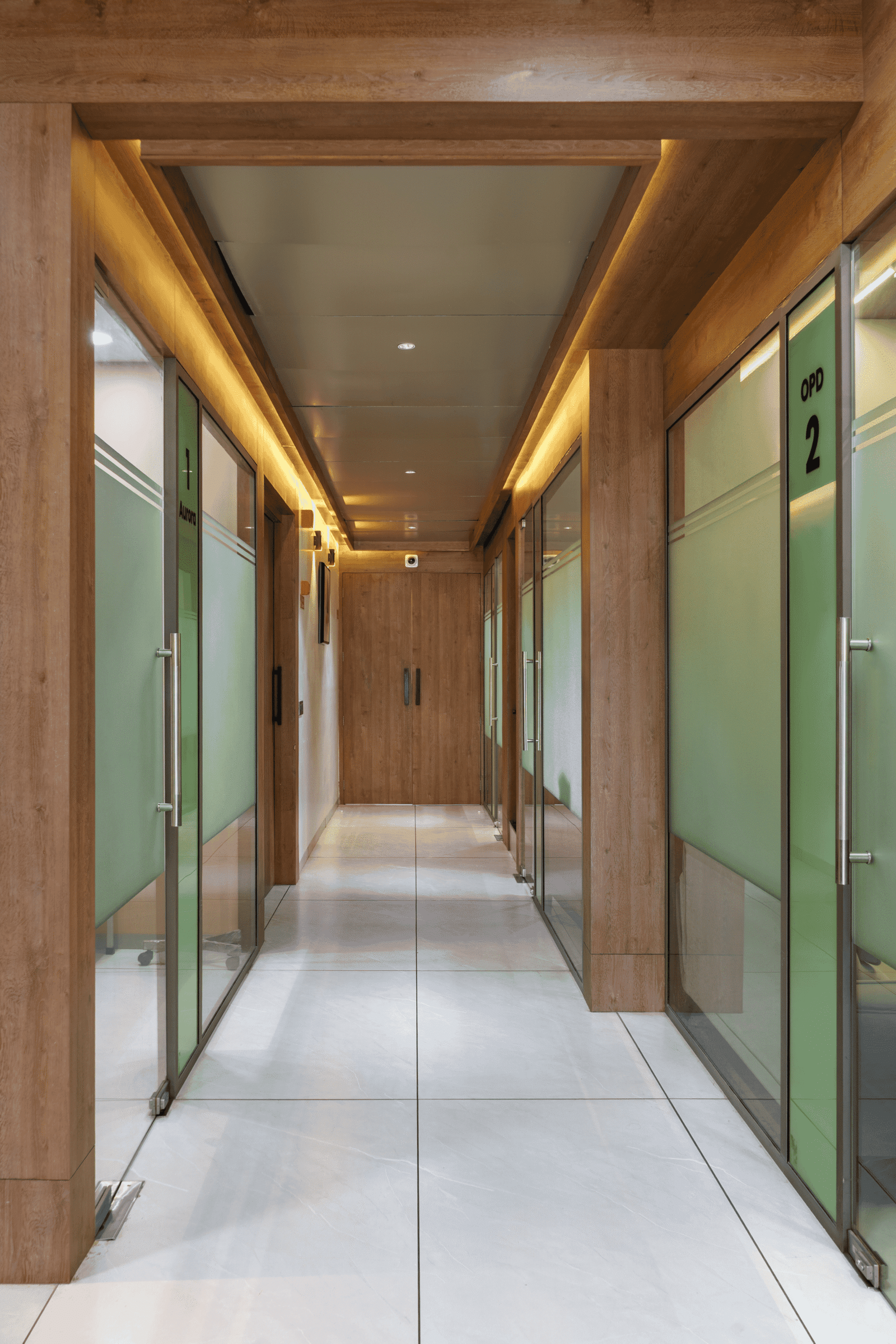 Reception and waiting area of Olwen Hospital in Ahmedabad designed by Vastu Nirman Architects featuring warm wood finishes and calming interior design