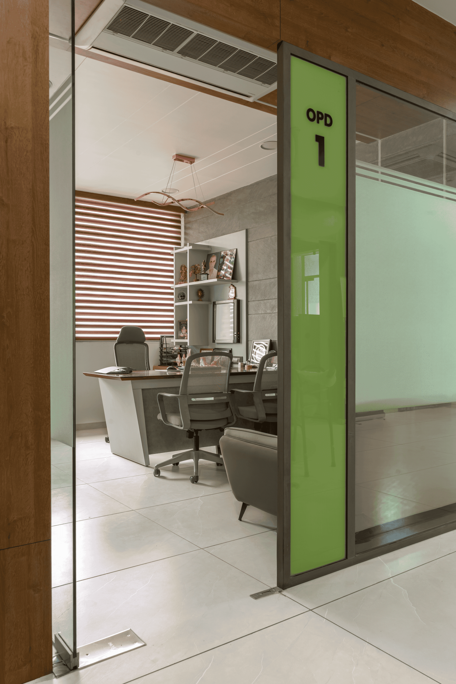 Reception and waiting area of Olwen Hospital in Ahmedabad designed by Vastu Nirman Architects featuring warm wood finishes and calming interior design