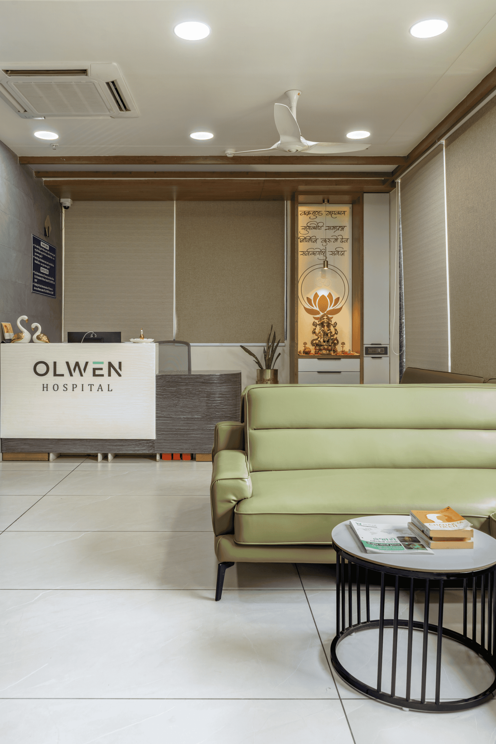 Reception and waiting area of Olwen Hospital in Ahmedabad designed by Vastu Nirman Architects featuring warm wood finishes and calming interior design