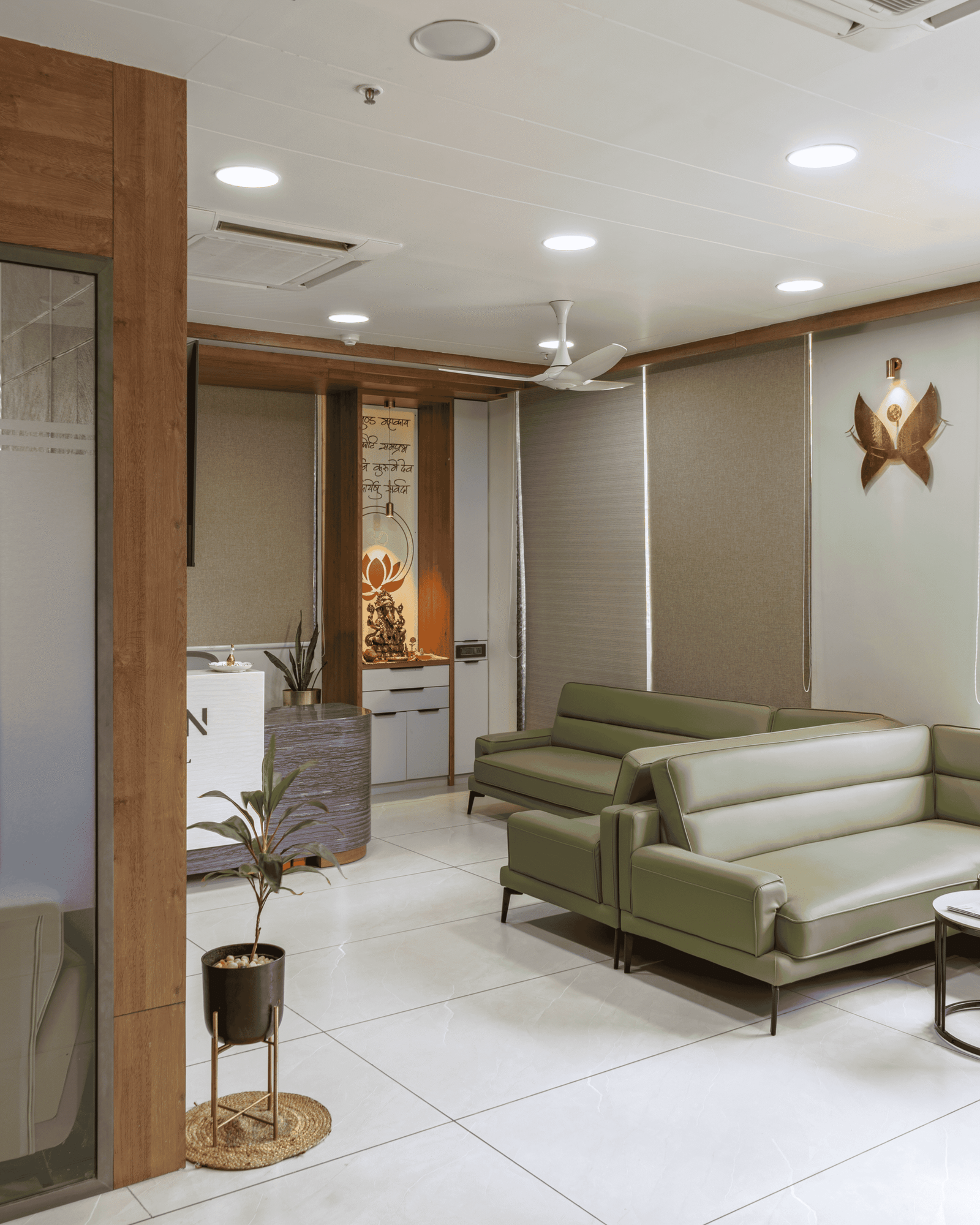 Reception and waiting area of Olwen Hospital in Ahmedabad designed by Vastu Nirman Architects featuring warm wood finishes and calming interior design