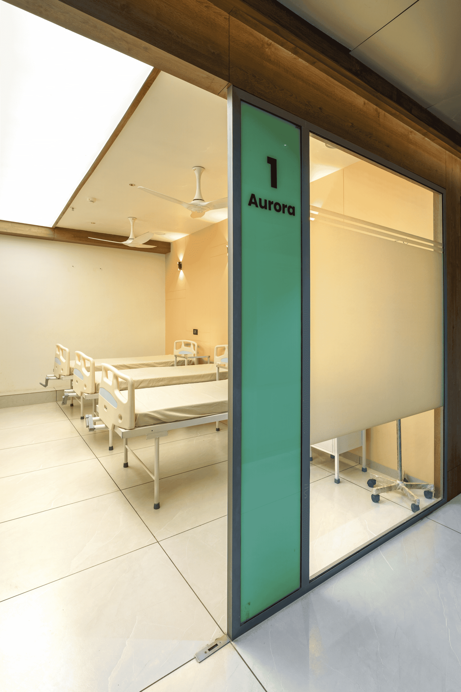 Reception and waiting area of Olwen Hospital in Ahmedabad designed by Vastu Nirman Architects featuring warm wood finishes and calming interior design