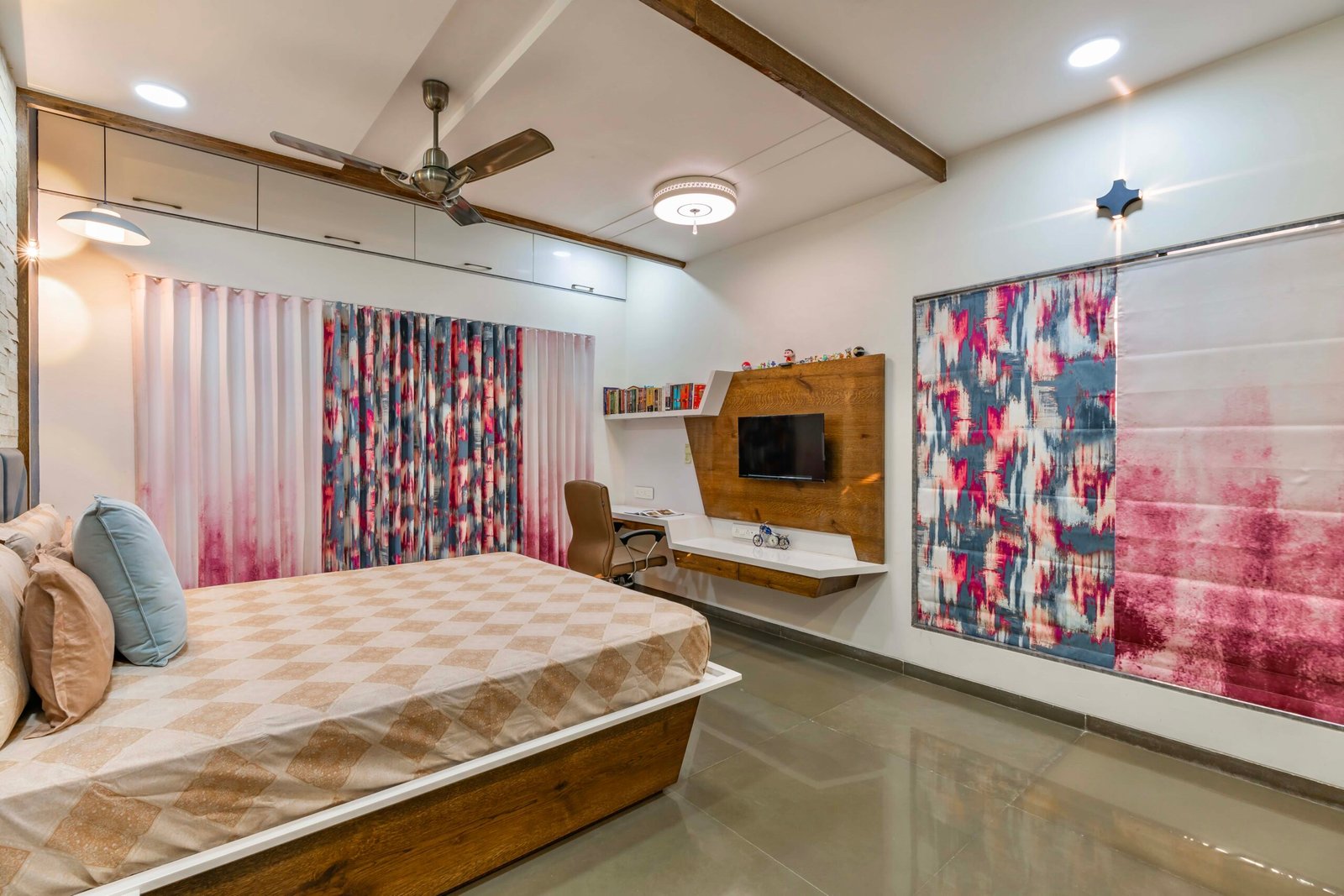 - Modern bungalow facade with exposed concrete, stone cladding, and wooden louvers in Ahmedabad - Sandstone-clad entrance with illuminated staircase and landscaped exterior - Open-plan living and dining area with geometric partition and modern chandelier - Master bedroom with blue textured wallpaper, wooden ceiling grid, and floating bedside units - Guest bedroom with geometric headboard, floating desk, and accent lighting - Polished flooring, natural wood finishes, and integrated lighting in modern residential interior