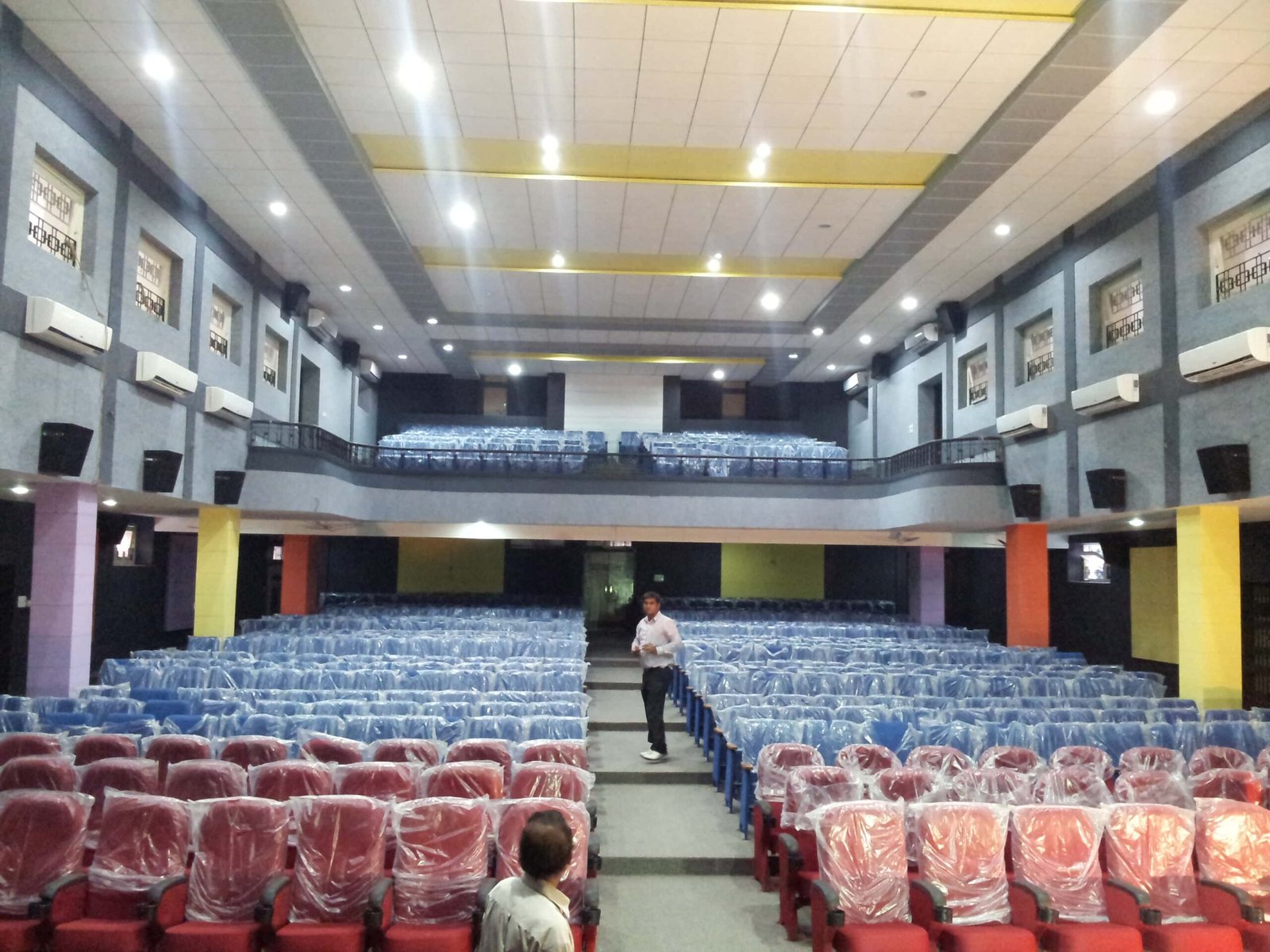 - Front elevation of the restored Sardar Townhall in Rajpipla, showcasing the heritage façade with ornate cornices and columns - Interior view of the refurbished hall with vibrant wall murals, contemporary seating, and updated lighting fixtures - Close-up of decorative plasterwork and restored wooden beams highlighting the building’s historical craftsmanship - Auditorium perspective featuring the renovated stage, modern AV equipment, and flexible seating layout - Nighttime shot of Sardar Townhall illuminated to accentuate architectural details and the entrance canopy