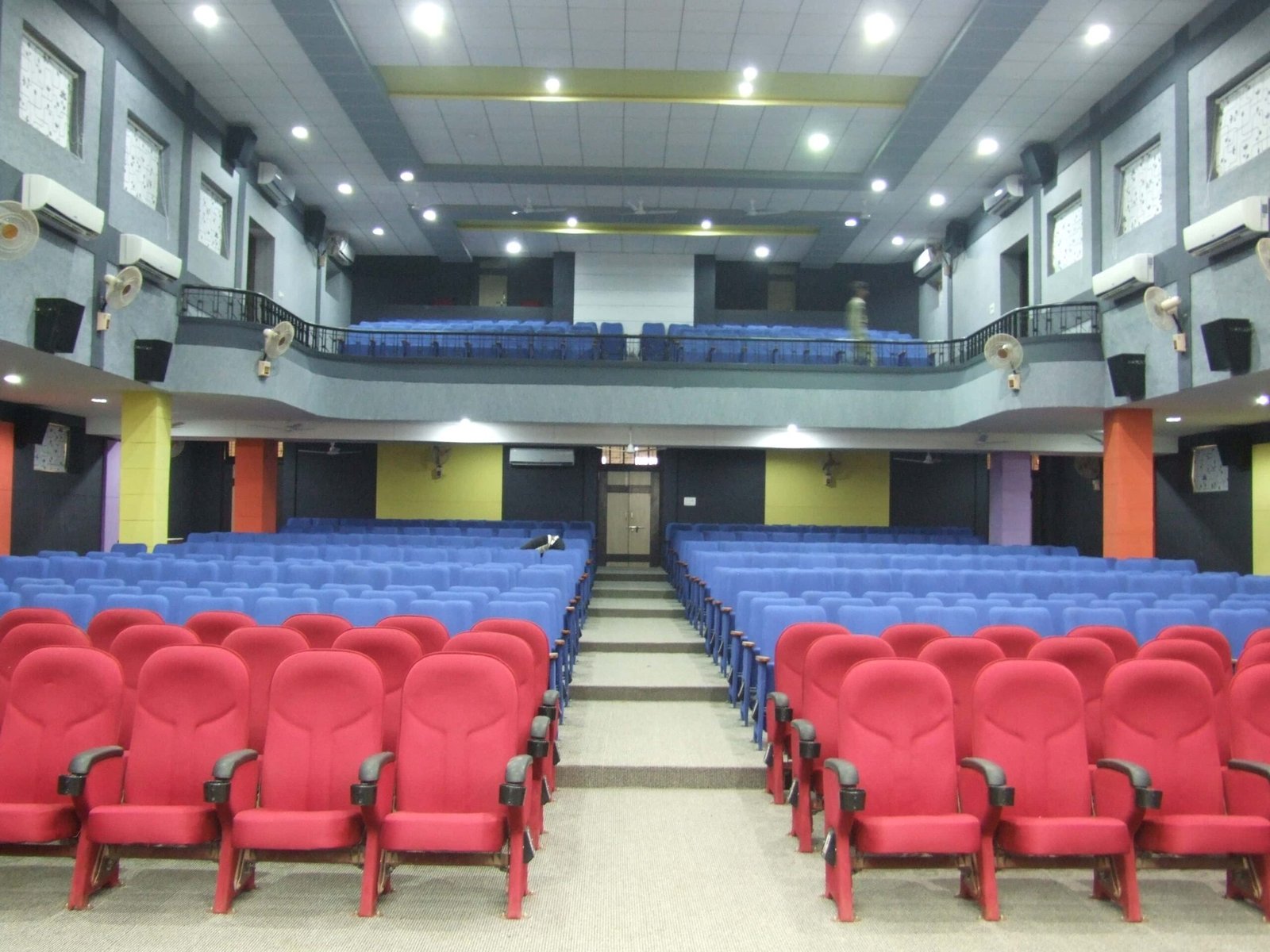 - Front elevation of the restored Sardar Townhall in Rajpipla, showcasing the heritage façade with ornate cornices and columns - Interior view of the refurbished hall with vibrant wall murals, contemporary seating, and updated lighting fixtures - Close-up of decorative plasterwork and restored wooden beams highlighting the building’s historical craftsmanship - Auditorium perspective featuring the renovated stage, modern AV equipment, and flexible seating layout - Nighttime shot of Sardar Townhall illuminated to accentuate architectural details and the entrance canopy