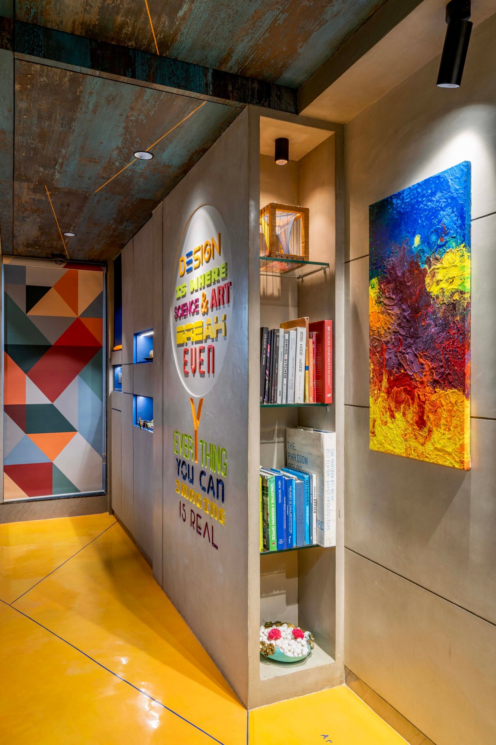-Exterior shot of Vastu Nirman Architects’ Office in Ahmedabad featuring a minimalist façade, green planter boxes, and entrance signage -Reception area with vibrant accent wall, sleek minimalist desk, and eco-friendly décor elements -Open-plan collaborative workspace showing adjustable desks, colorful partitions, and abundant natural light -Living wall installation and indoor plant clusters creating a green oasis within the office interior -Flexible brainstorming zone with modular seating, writable wall panels, and sustainable lighting fixtures