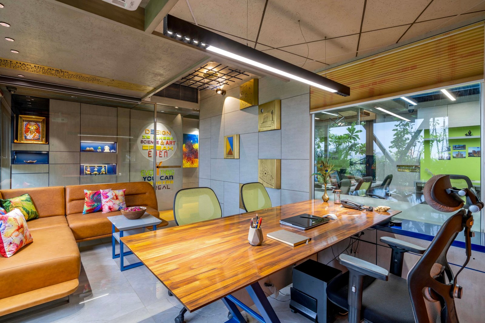 -Exterior shot of Vastu Nirman Architects’ Office in Ahmedabad featuring a minimalist façade, green planter boxes, and entrance signage -Reception area with vibrant accent wall, sleek minimalist desk, and eco-friendly décor elements -Open-plan collaborative workspace showing adjustable desks, colorful partitions, and abundant natural light -Living wall installation and indoor plant clusters creating a green oasis within the office interior -Flexible brainstorming zone with modular seating, writable wall panels, and sustainable lighting fixtures