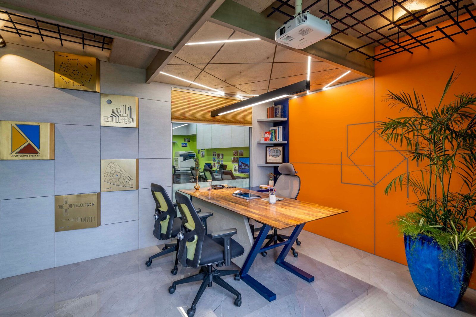 -Exterior shot of Vastu Nirman Architects’ Office in Ahmedabad featuring a minimalist façade, green planter boxes, and entrance signage -Reception area with vibrant accent wall, sleek minimalist desk, and eco-friendly décor elements -Open-plan collaborative workspace showing adjustable desks, colorful partitions, and abundant natural light -Living wall installation and indoor plant clusters creating a green oasis within the office interior -Flexible brainstorming zone with modular seating, writable wall panels, and sustainable lighting fixtures